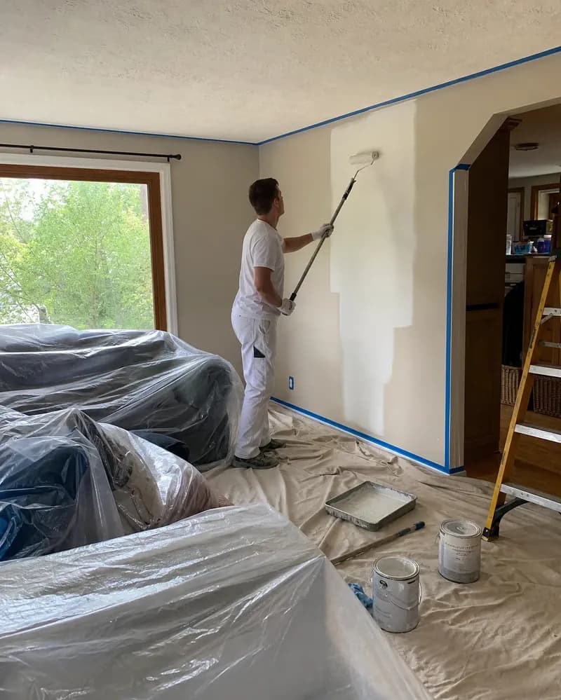 Interior painting in progress with furniture and floors protected